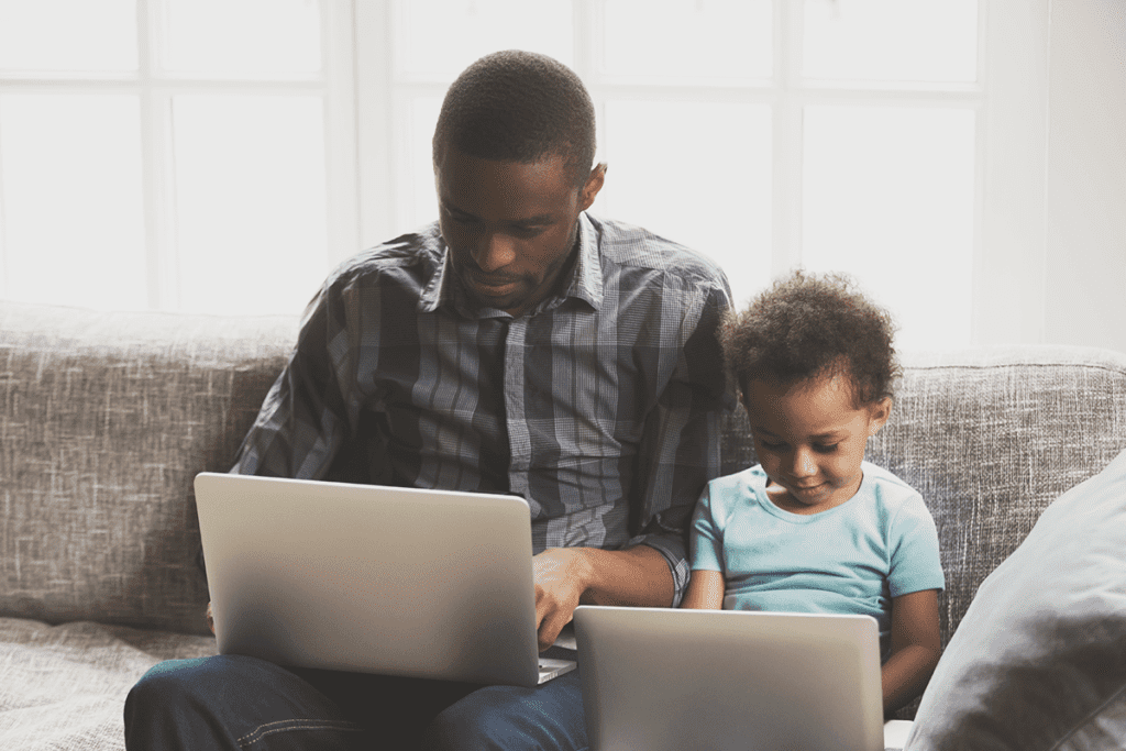 Internet safety tips for the family. A dad and his young son sit side by side, each using a laptop