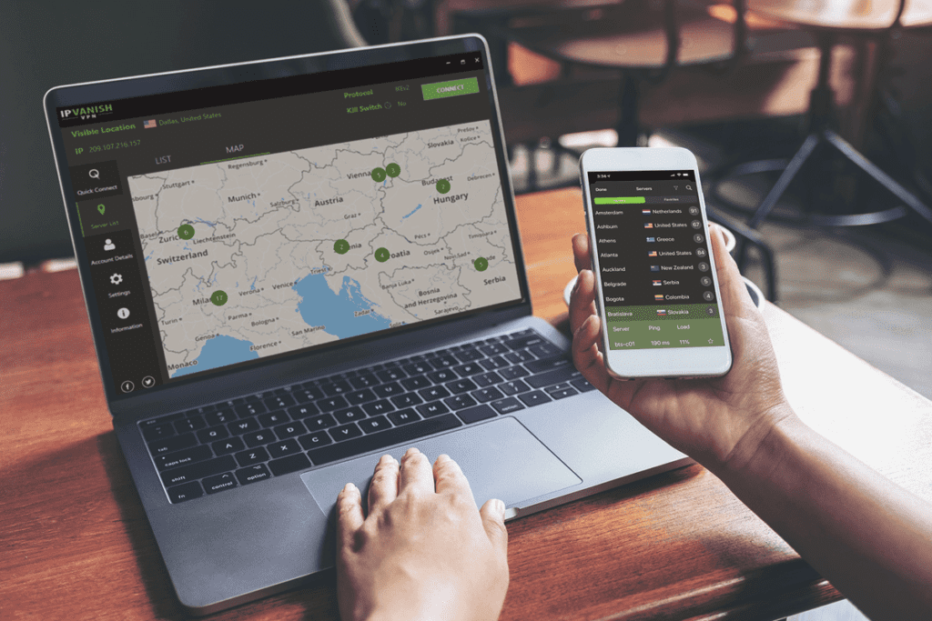 A person uses a laptop and cellphone in a cafe, both with the silverbackvpn internet privacy app enabled