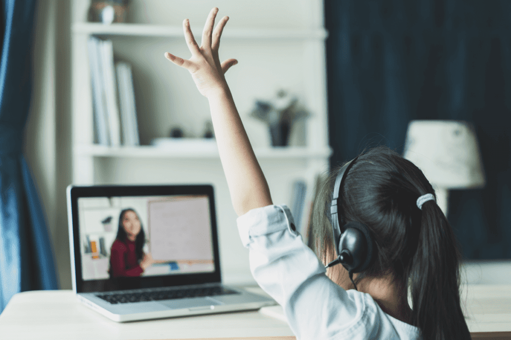 a young girl in virtual classroom with hand raised for teacher is learning cybersecurity best practices