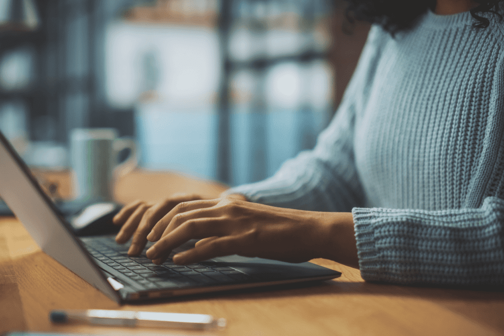 Anonymous email sending visualized. A woman hand's type on a laptop keyboard, her identity cropped out of frame