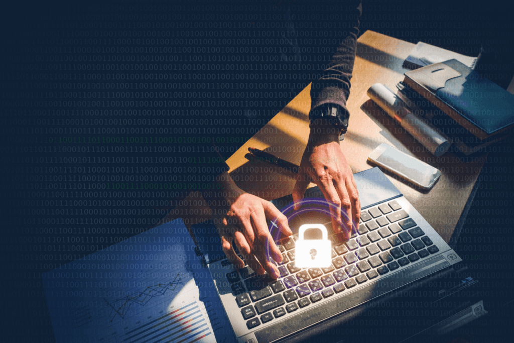 Secure online privacy predictions visualized. Hands are seen extending from a shadowed area to type on a laptop with a padlock.