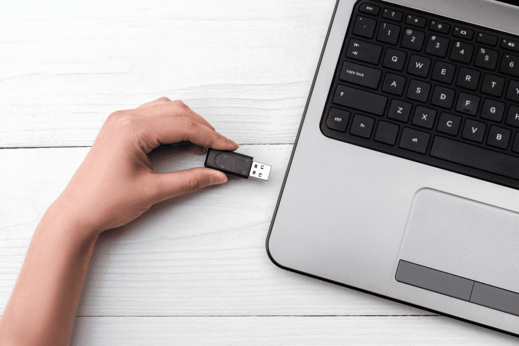 Person's hand inserting an encrypted flash drive into a laptop