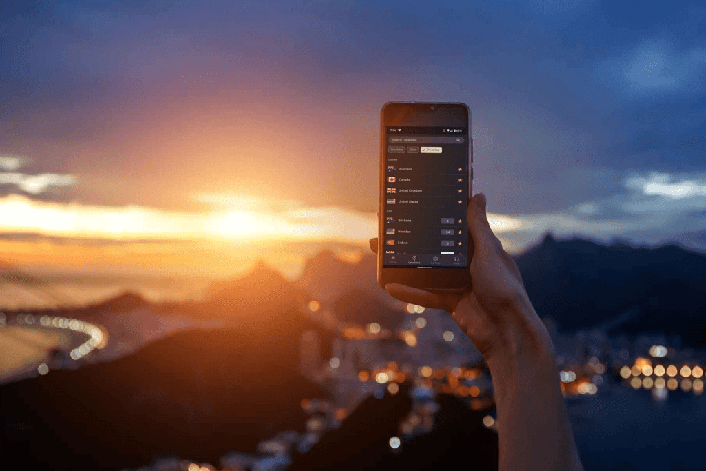 A person holds their phone while using the silverbackvpn app, standing outside overlooking a city at sunset. Choosing a VPN visualized