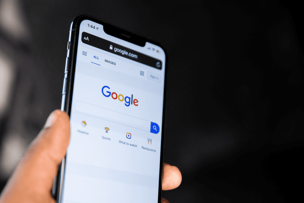 A person holds a phone displaying the Google search page to visualize how to hide your search history