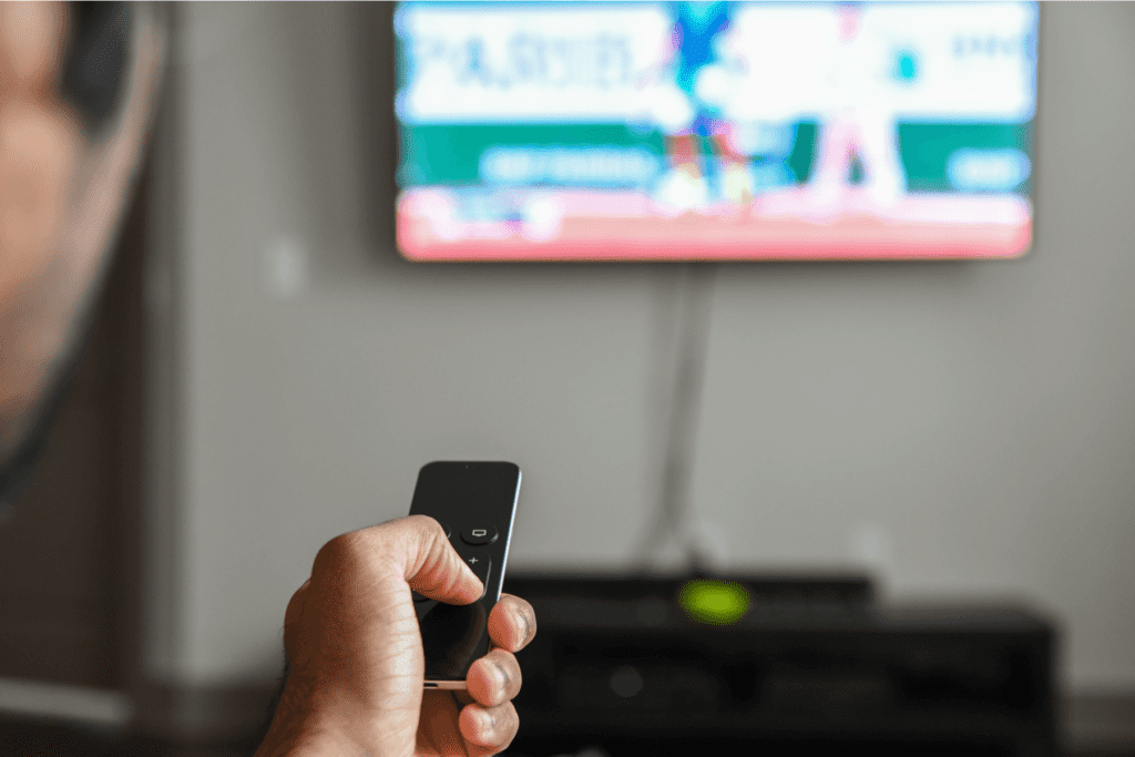 hand holds apple tv remote to close apps