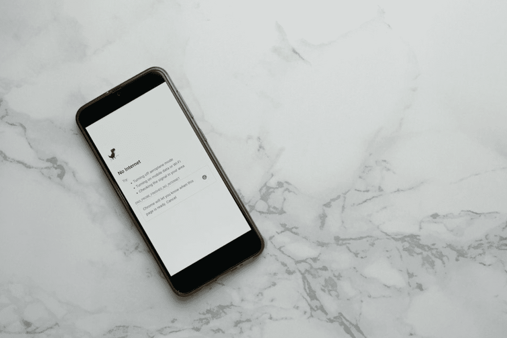 A phone rests on a table with a display showing no internet connection. How to test VPN kill switch visualized