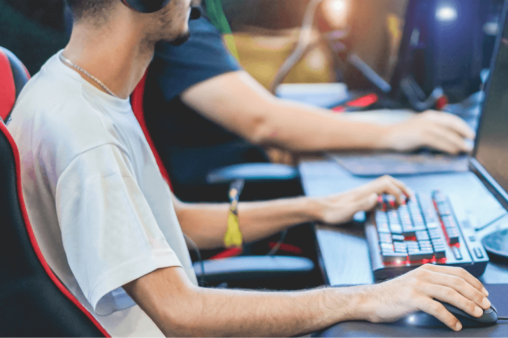 A group of young people each with a computer play games online together; a LAN party