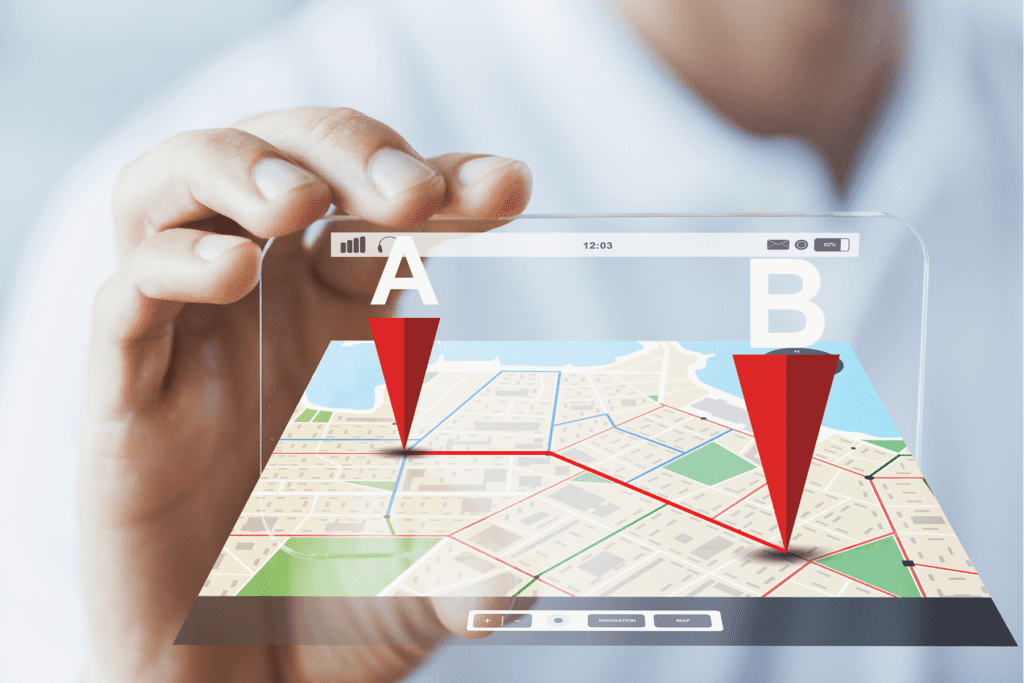 A man holds a device showing two GPS location pins on a map to visualize GPS spoofing