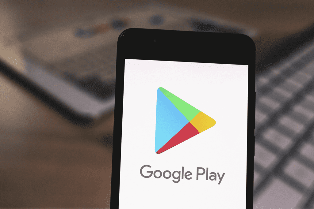 A phone displays the Google Play Store as a person figures out how to delete google play store