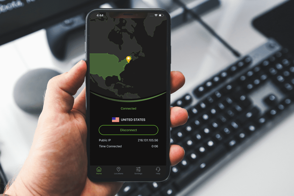 A man holds his iPhone which is open and displaying the newSilverBackVPNiOS VPN app on the home screen