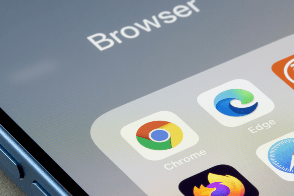 A phone displays different browser apps as a person figures out how to clear browser search history