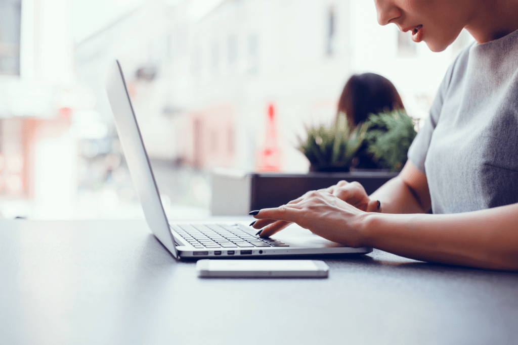A person is seen from their profile sitting to use a laptop, visualizing an OpenVPN Mac setup