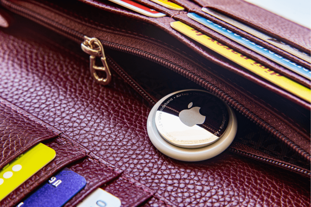 An Apple AirTag is seen near the zipper compartment of a wallet. This is likely intention but could be an instance of AirTag stalking