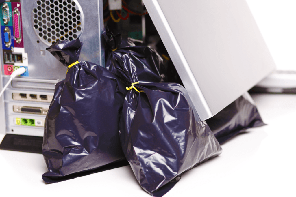 Trash bags come out of the side of a computer tower, visualizing the useless, garbage software that bloatware is perceived as.