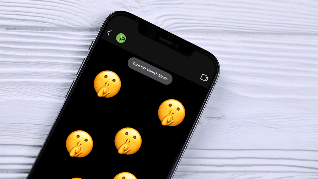 A phone is seen on a table open to Vanish Mode on Messenger