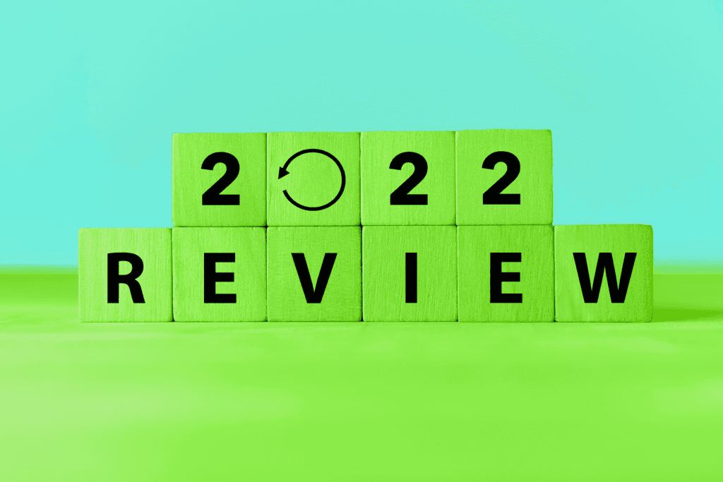 Green building blocks spell out the words "2022 Review" in front of a blue background, decorative image for a 2022 recap