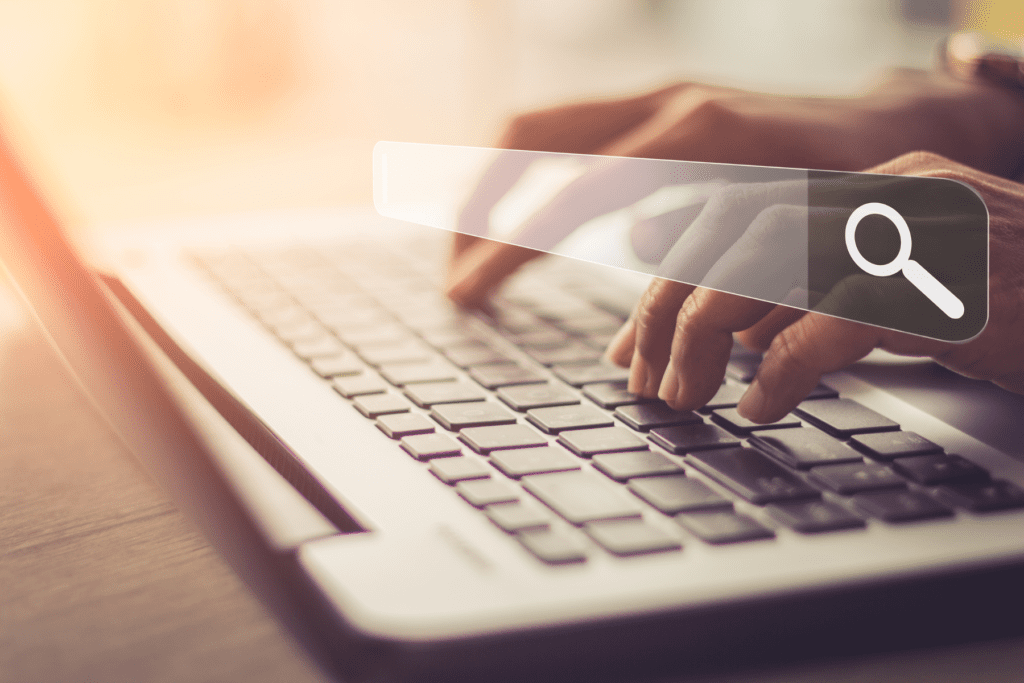 The hands of a person are shown typing with a bar across the screen to deliberate whether it is a web browser vs. search engine.