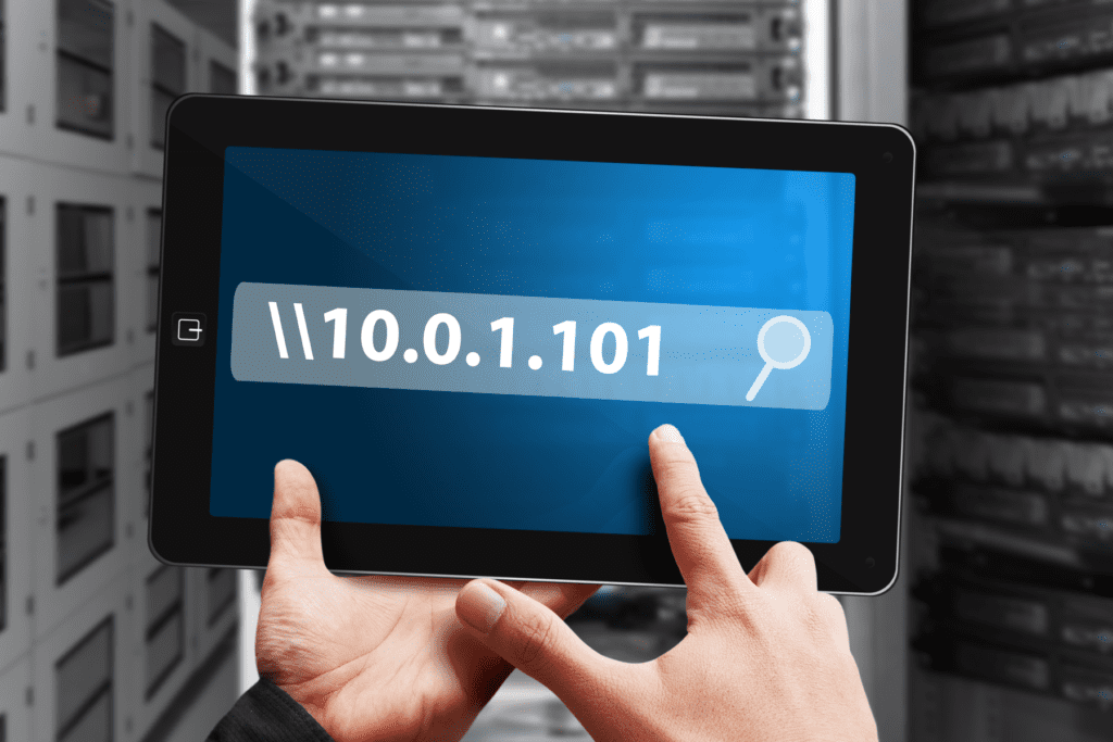 An IP address is searched for on a tablet display in a server room, depicting what can someone do with your IP address