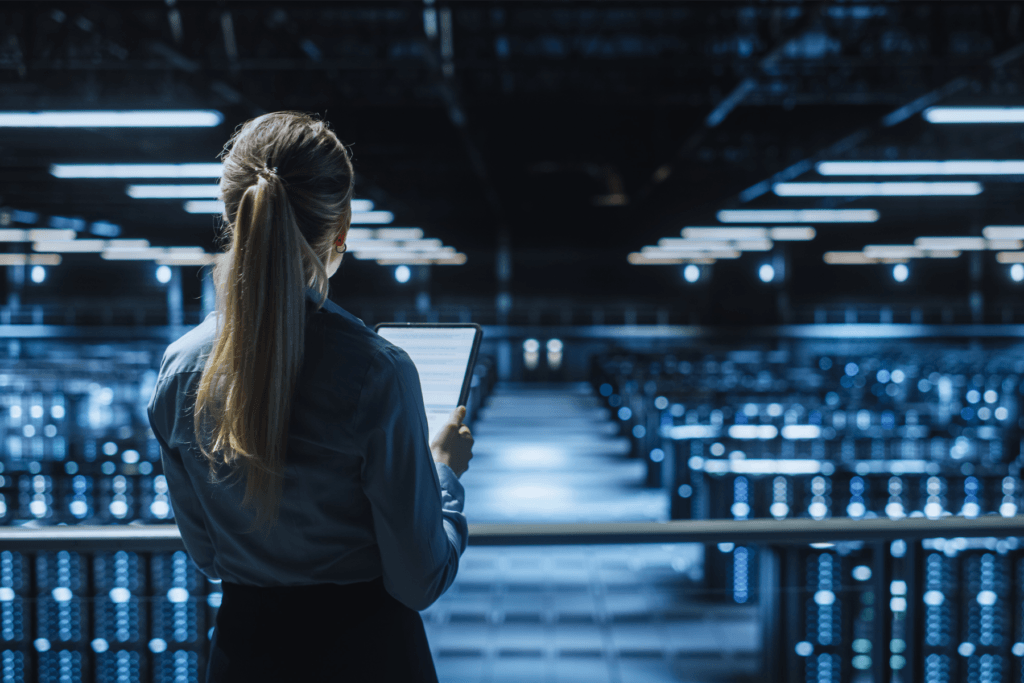 A woman stands overlooking servers while holding a list to determine the best VPN city server selection