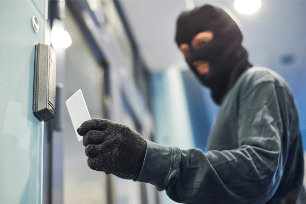 Burglar entering a building with a stolen key to show how piggybacking works on a network.