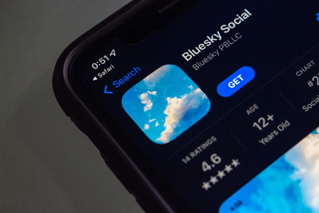 A photograph of an iPhone displaying the Apple App Store listing for Bluesky Social.