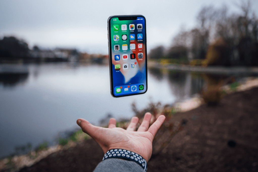 An iPhone freely floats above a person's extended hand in a tranquil space to visualize a free VPN for iPhone