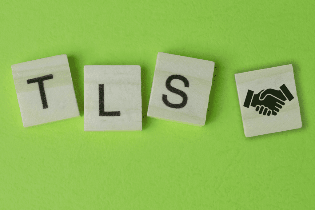 Scrabble letters on a green table spell out "TLS" with a handshake icon to depict a TLS handshake