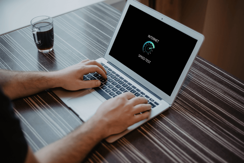 Photo of a person using a laptop that appears to be running a VPN speed test.
