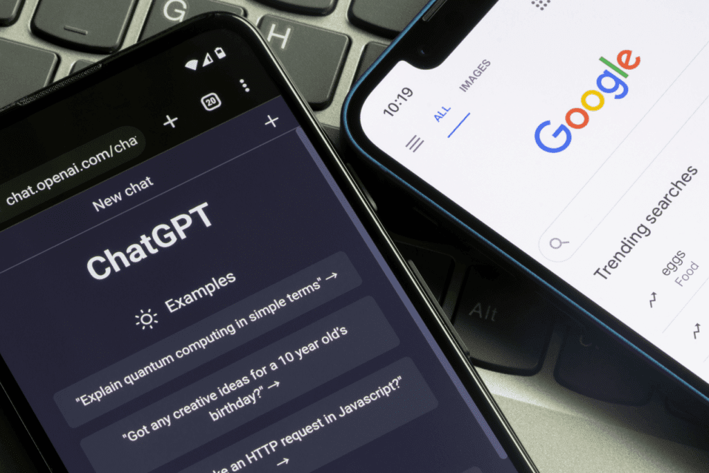 Photograph of two phones on a keyboard displaying Bard vs. ChatGPT