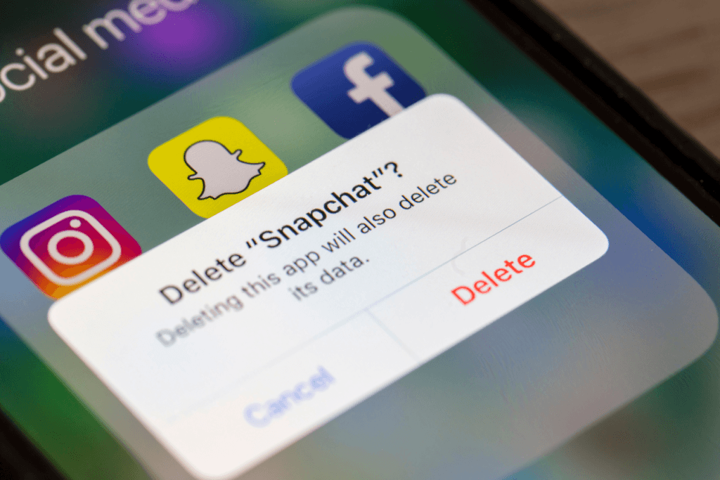 A photograph of a smartphone prompting the user to delete Snapchat.
