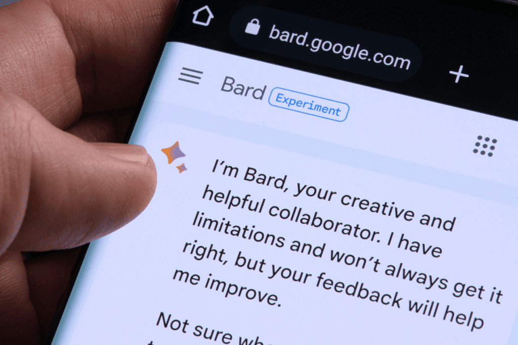Close-up photo of a phone showing what is Google Bard and a hand.