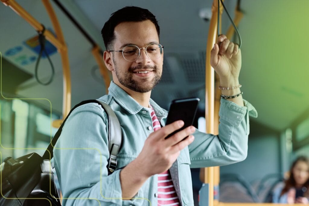 man looking at phone on public transit, what is tethering