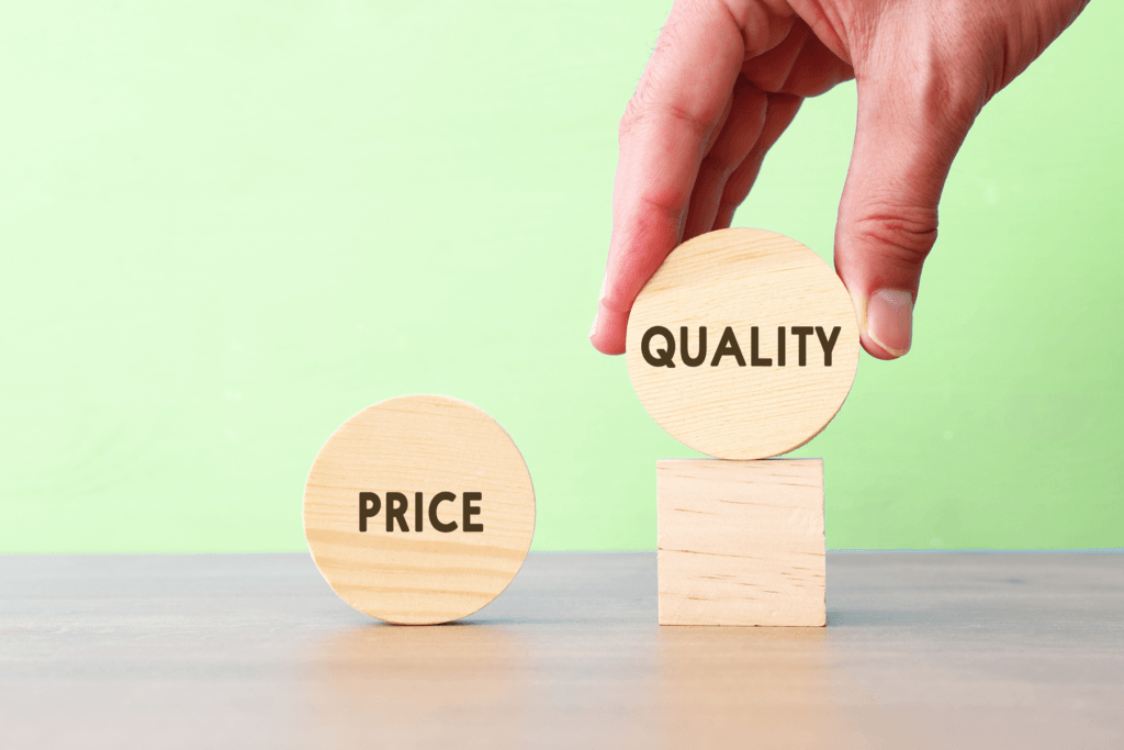 A visual block with the word "Quality" is held by a hand, leaving behind the block labeled with the word "Price", decorative image of why the cheapest VPN is not always the best