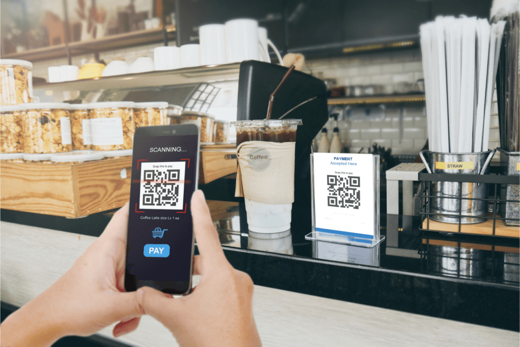 Photograph of someone scanning a QR code in a cafe.