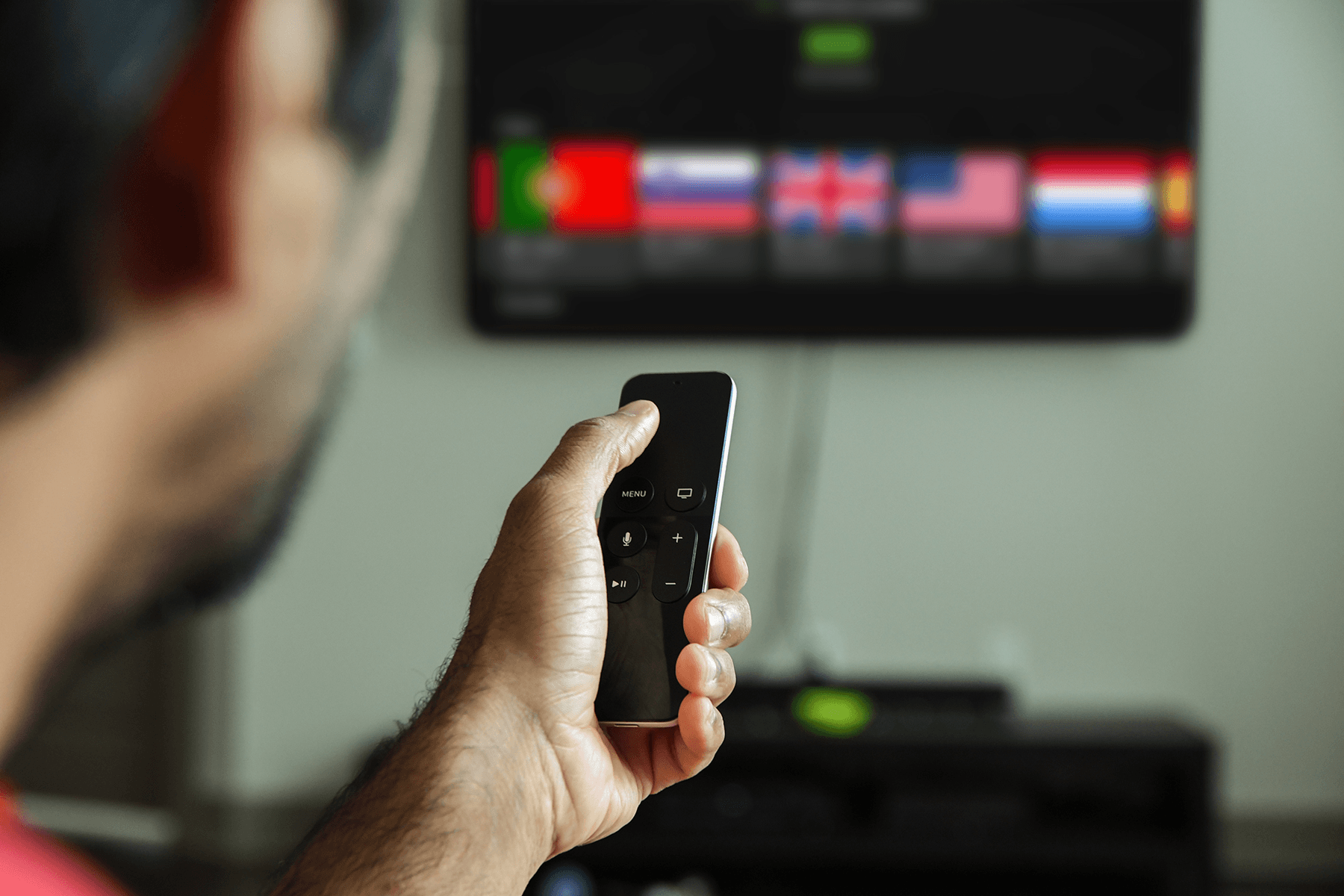 A man is seen using theSilverBackVPNVPN app for Apple TV while holding a remote