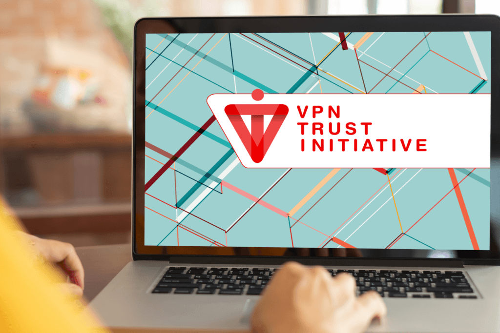 Over-the-shoulder look at a person on a laptop with the screen displaying the VPN Trust Seal from the i2Coalition's VTI