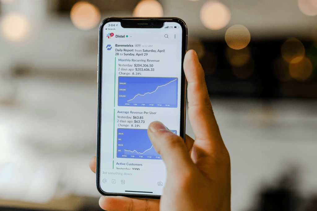 A person on their phone open to the Slack app for the question 'does Slack track you?'