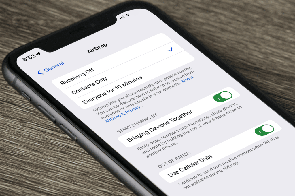 An iPhone on a table is open to display the visibility mode settings for AirDrop to help answer the question is AirDrop safe