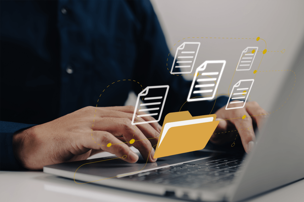 Picture shows person at a computer desk with a visual of files appearing to depict how to transfer files from windows to mac
