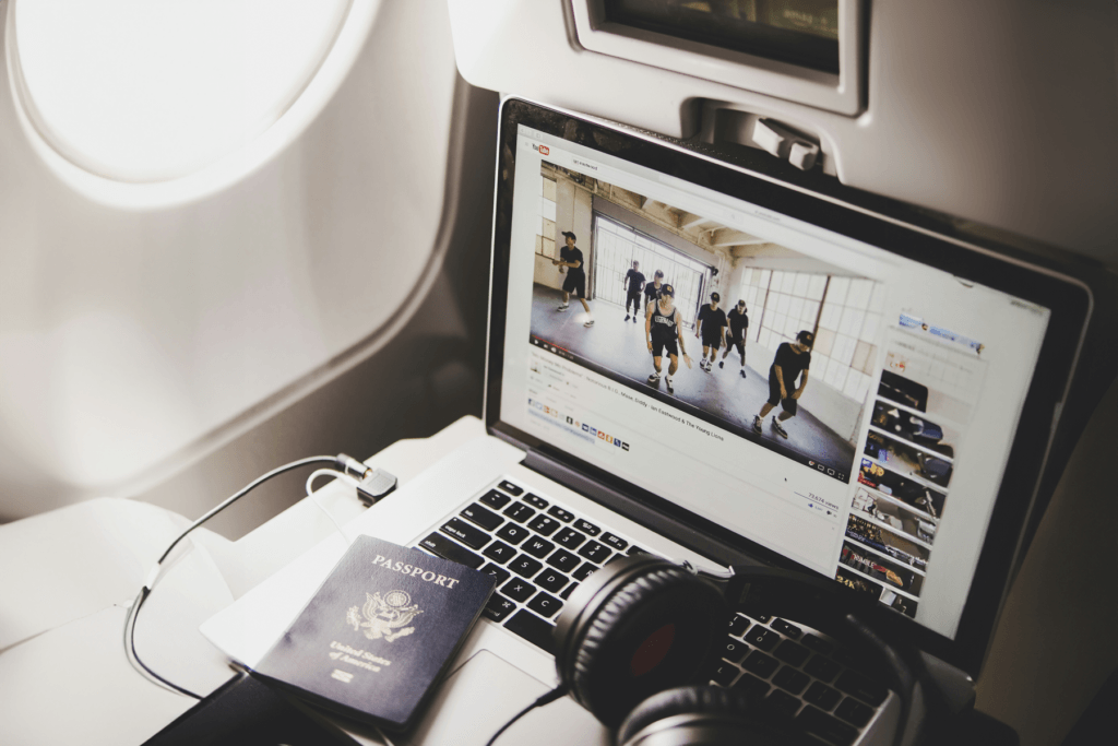 Image of a person using a computer on an airplane - use the in-flight wi-fi with the display open to YouTube