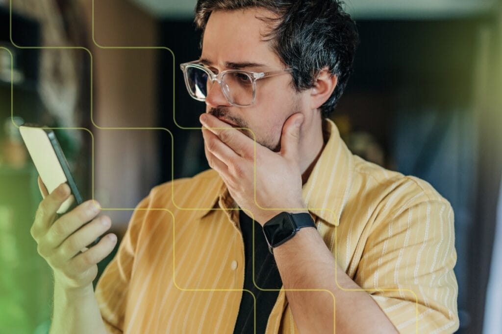 man looking surprised while looking at phone
