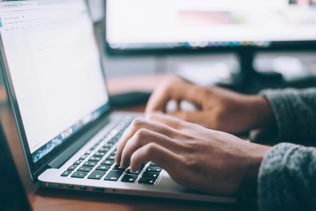 A man sits at a laptop with obscured display, decorative image depicting manually change IP address info