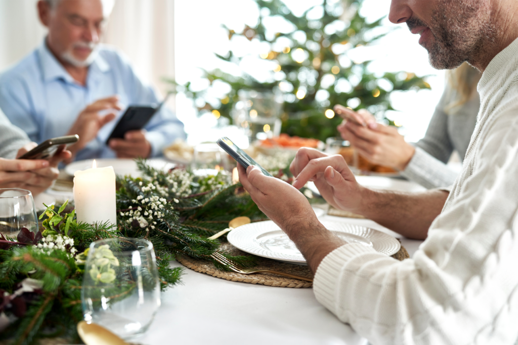 A family at the holiday table with phones having a discussion