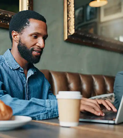 man at a cafe working on laptop