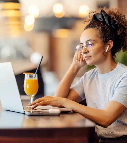 Woman at cafe working on laptop