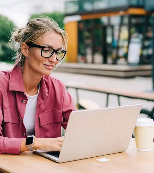 Woman using laptop at outdoor cafe