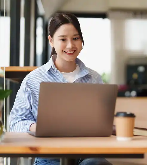 Woman at a cafe looking at laptop